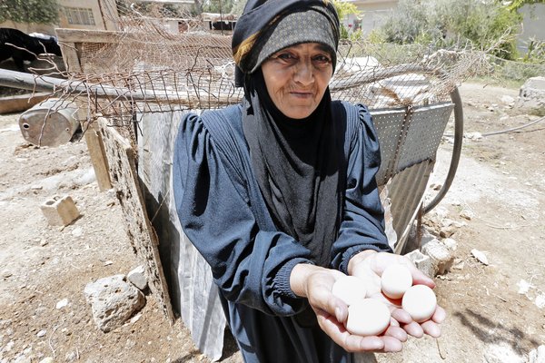 Une femme avec des oeufs dans la main.